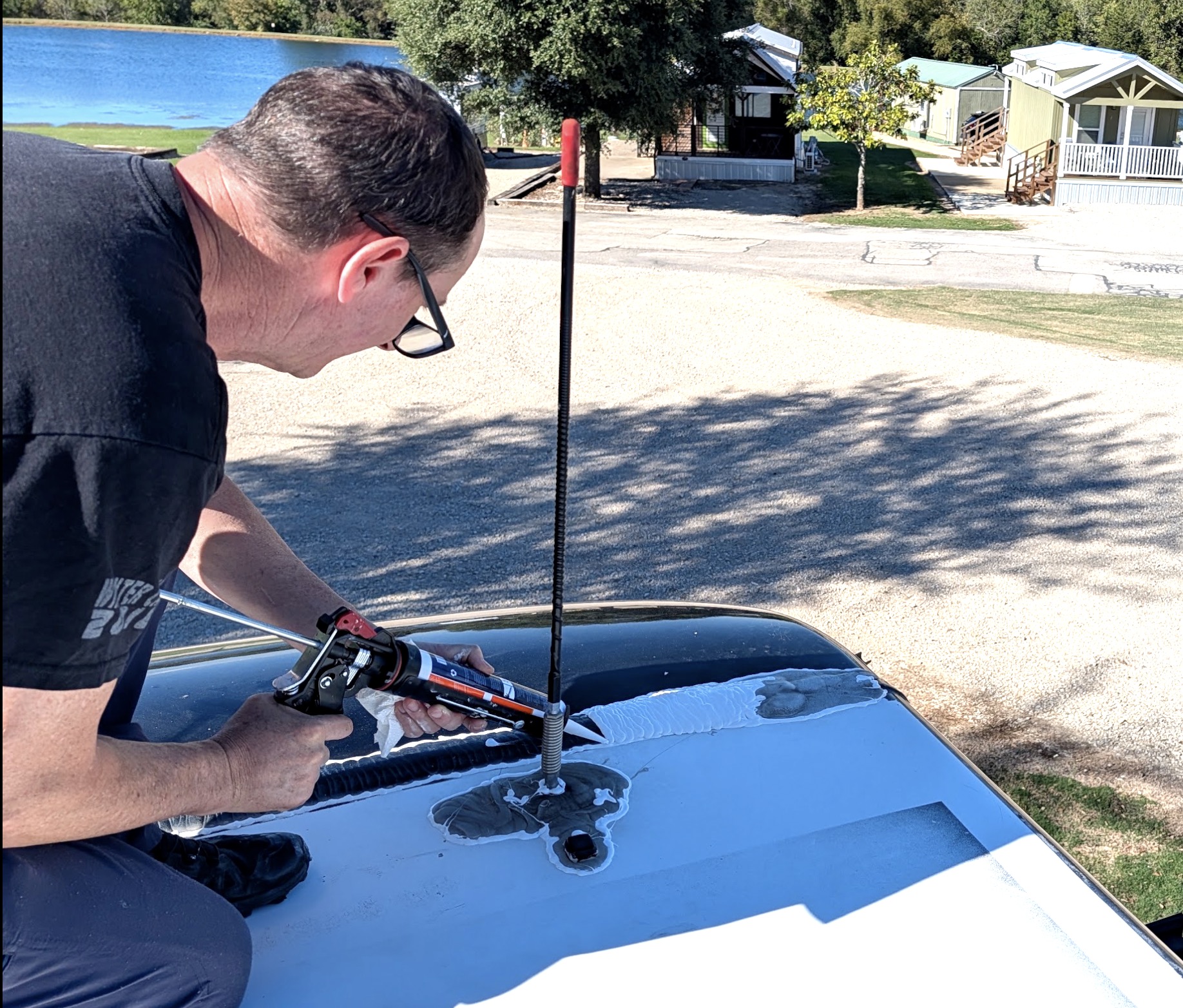 RV Tech applying sealant to an RV roof.